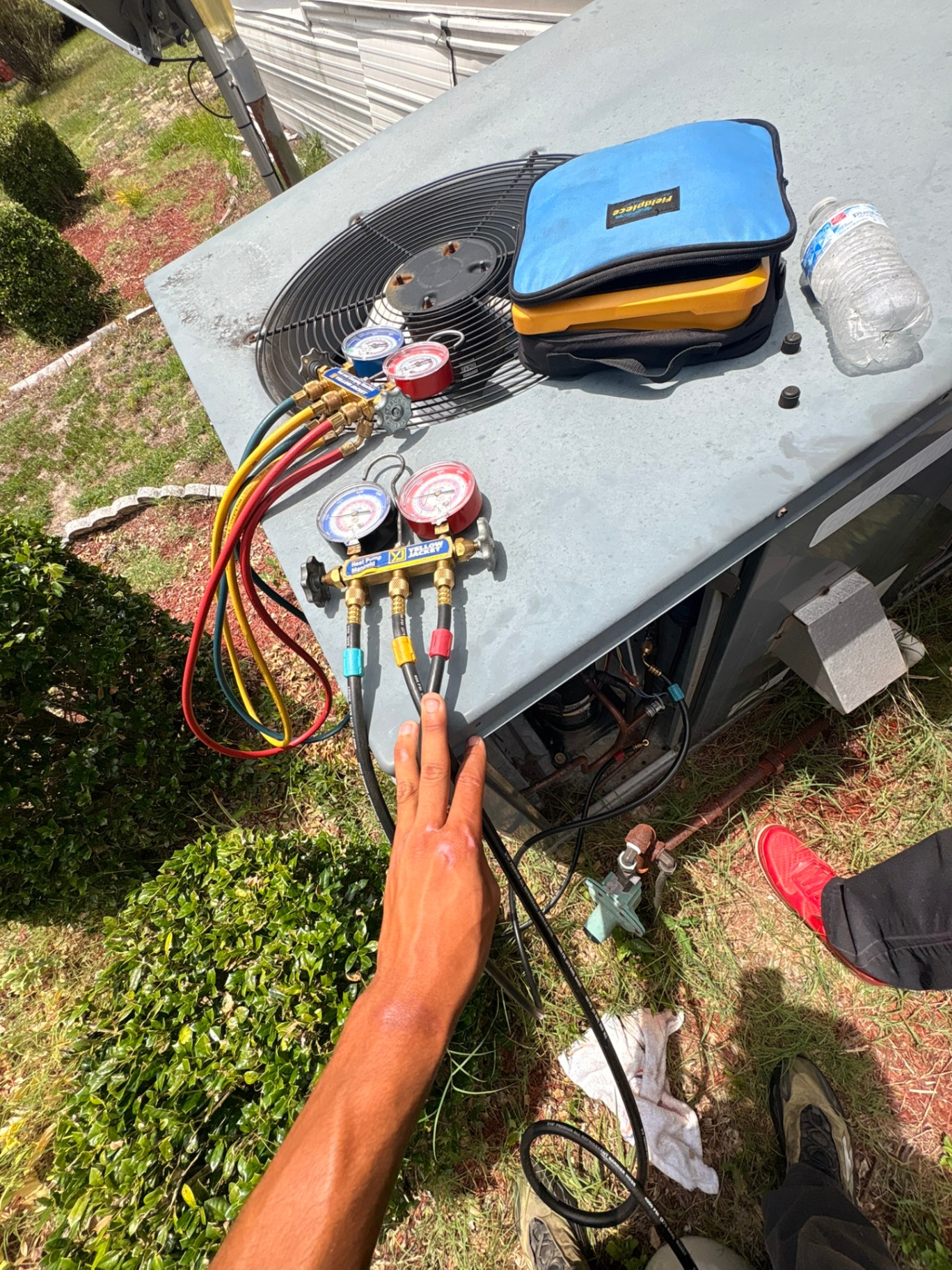Perfect Temp technician checking refrigerant pressures with gauge manifolds during a service call